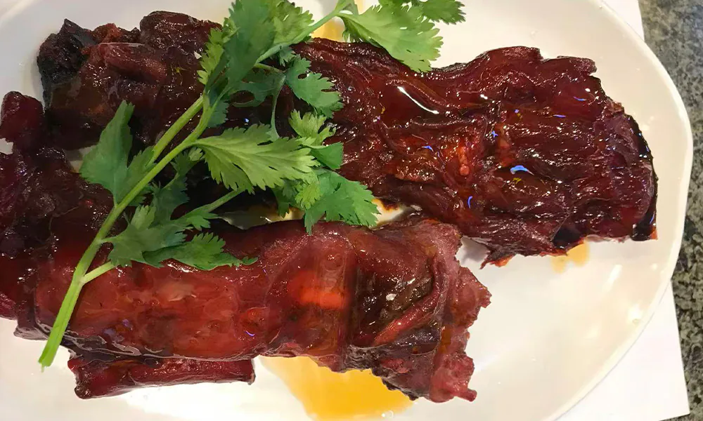 Glazed savory saucy pork ribs with cilantro at Gourmet Duck 绝味鸭霸王，a Chinese Restaurant in Chicago